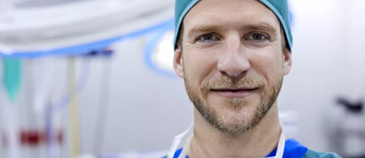 Ready to set up or join a Anaesthetic Group Practice 1 Portrait of confident male surgeon in operating room. Mid adult healthcare worker is in hospital. He is wearing surgical cap.